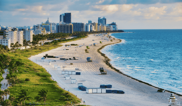 Miami beach coastline with high rises blue water, and green sea grass. 