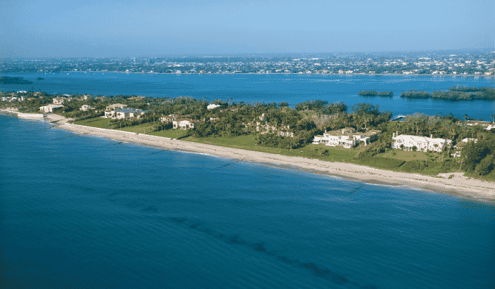 An aerial view of Vero Beach Florida with a long coast, green trees, and houses