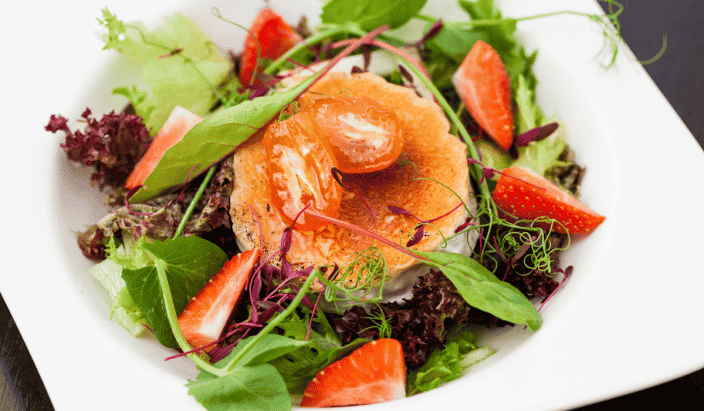 warm goat cheese salad with fresh strawberries, mixed greens, and tomatoes