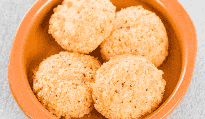 fried goat cheese balls in a orange ramekin to use in warm goat cheese salad