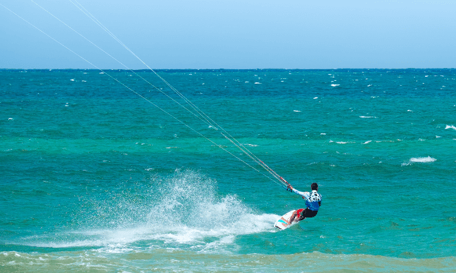 a man kite-surfing on the waves at Hadicurari Beach in Aruba