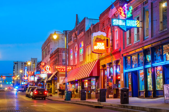 colorful cafe bars at the iconic Beale Street music and entertainment district of downtown Memphis, Tennessee, USA, illuminated at night.