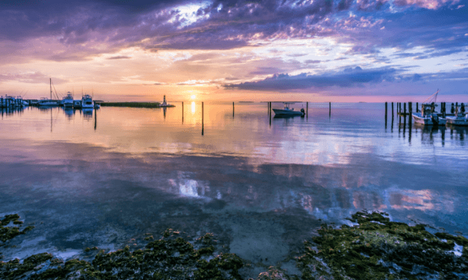 Boats docked in Islamorada with purple skies and golden sunset, a beautiful place for a romantic getaway on the beach
