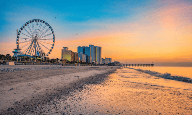 sunset at myrtle beach with a large ferris wheel and sandy beaches