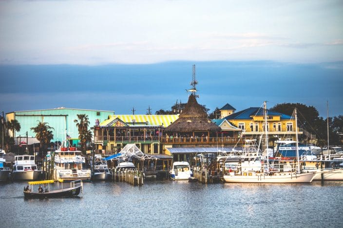 boats tied up on the dock with colorful buildings in the background