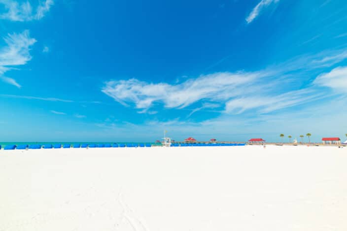 a beach with a blue sky and clouds