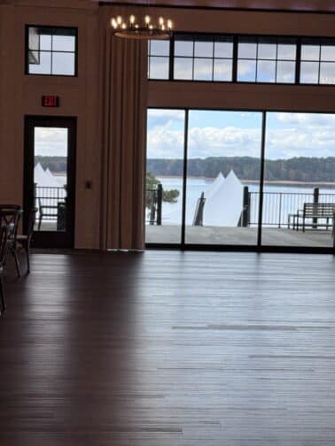 a room with a large glass wall and a large white boat in the distance