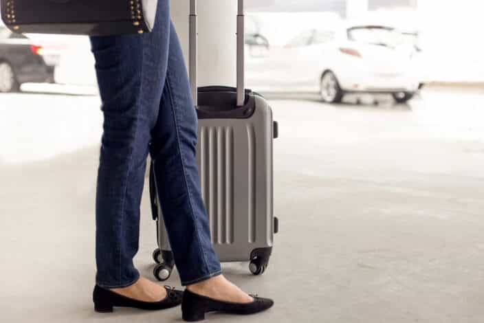 a person standing next to a suitcase