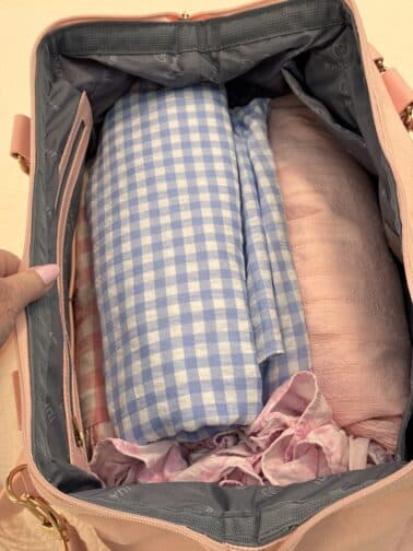 a hand holding a bag with clothes inside
