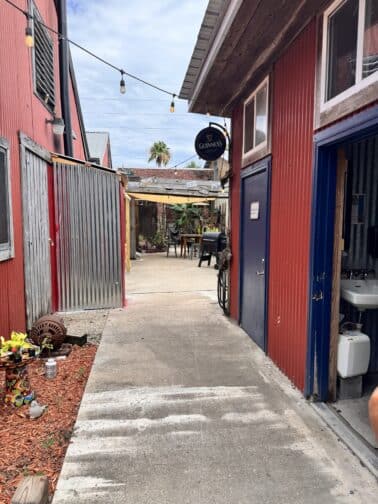 a walkway between buildings with a red wall