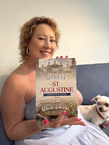 Betsi Hill holding book with dog